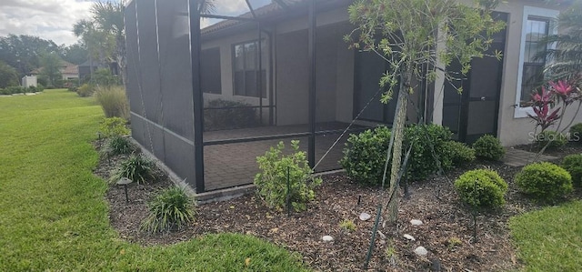 view of property exterior with a lawn and a lanai
