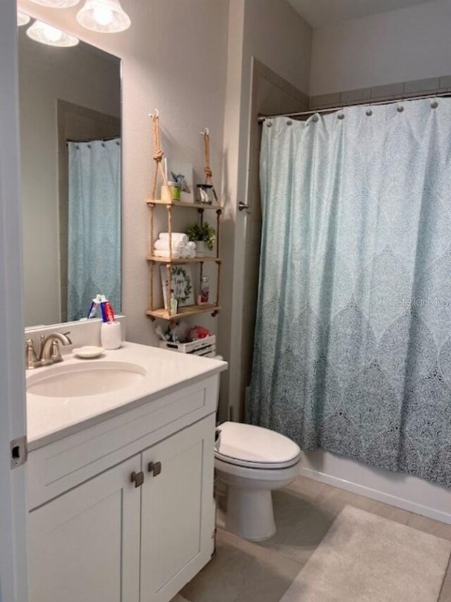 bathroom featuring vanity, tile patterned flooring, and toilet