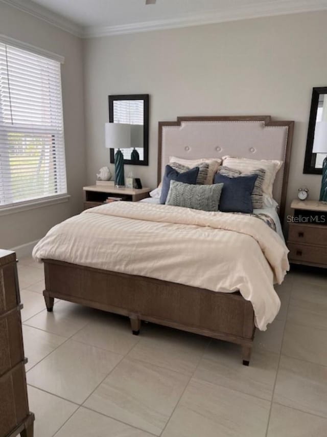 bedroom featuring crown molding, baseboards, and light tile patterned floors