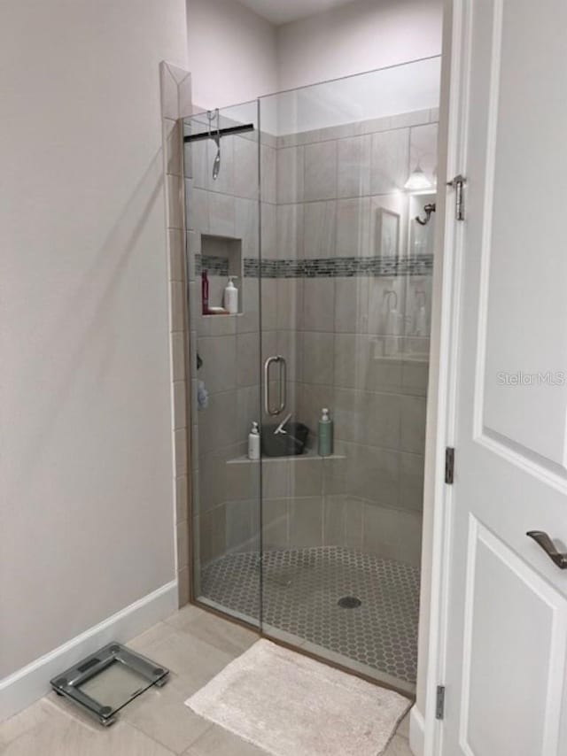 bathroom with baseboards and a stall shower