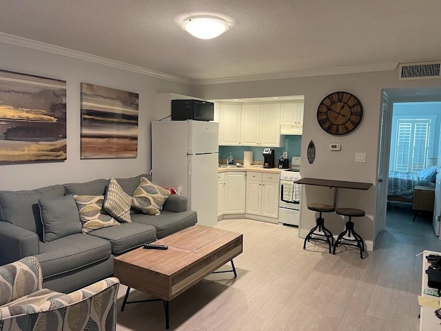 333 Island Way Unit 203, Clearwater Beach, FL 33767 - living area with visible vents, light wood finished floors, a textured ceiling, and crown molding