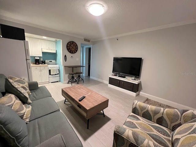 333 Island Way Unit 203, Clearwater Beach, FL 33767 - living room featuring light wood-style floors, crown molding, visible vents, baseboards, and a textured ceiling