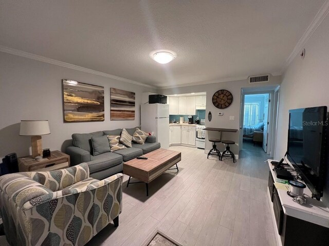 333 Island Way Unit 203, Clearwater Beach, FL 33767 - living room with visible vents, light wood finished floors, and crown molding