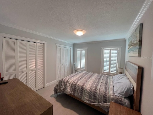 333 Island Way Unit 203, Clearwater Beach, FL 33767 - bedroom with a textured ceiling, two closets, ornamental molding, and light wood-style floors