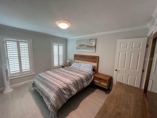 333 Island Way Unit 203, Clearwater Beach, FL 33767 - bedroom with baseboards, crown molding, a textured ceiling, and light wood finished floors