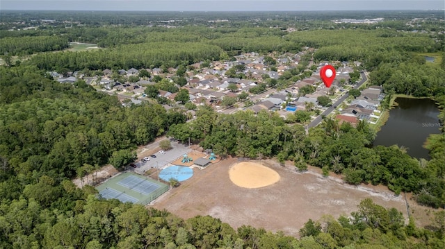 aerial view of property and surrounding area featuring a large body of water and a forest