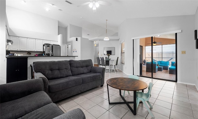 living room with a ceiling fan, light tile patterned floors, baseboards, and high vaulted ceiling