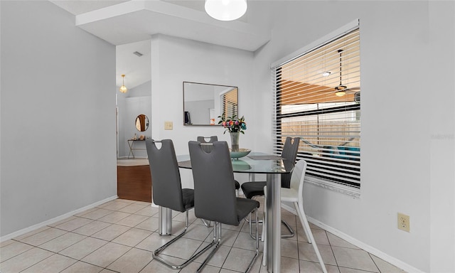 dining area featuring light tile patterned flooring, baseboards, and lofted ceiling