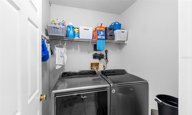 washroom featuring independent washer and dryer and a textured ceiling