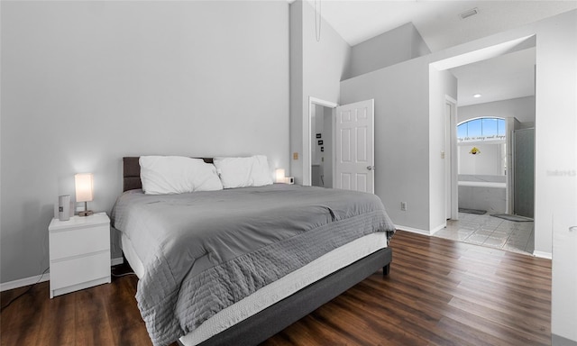 bedroom featuring baseboards, wood finished floors, and connected bathroom