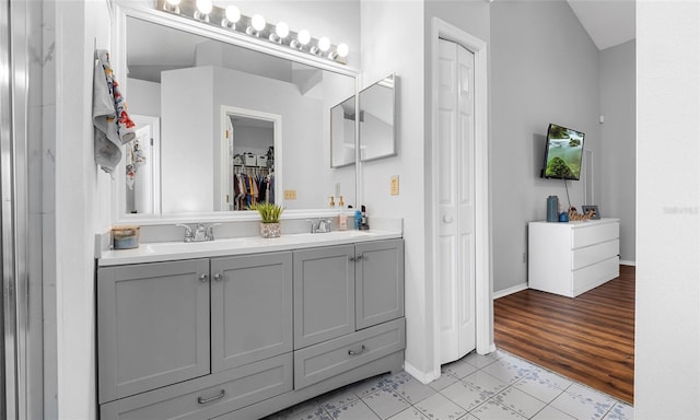 bathroom with double vanity and baseboards