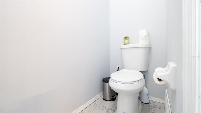 bathroom with baseboards, toilet, and tile patterned flooring