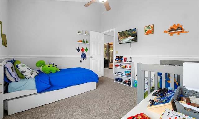 bedroom featuring carpet, a ceiling fan, and a towering ceiling