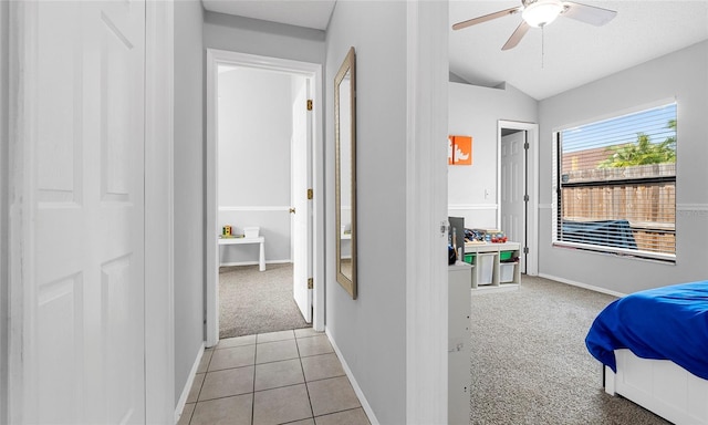 bedroom with light carpet, lofted ceiling, baseboards, and a ceiling fan
