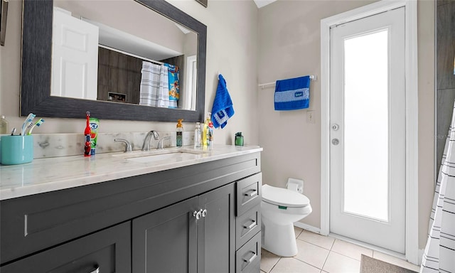 full bath with tile patterned flooring, vanity, and toilet