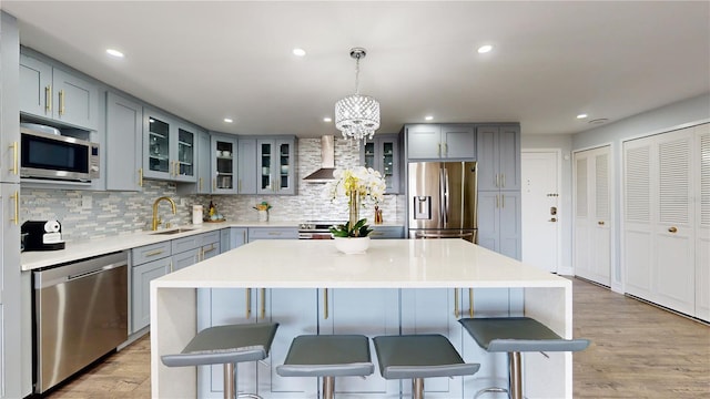 400 Island Way Unit 210, Clearwater Beach, FL 33767 - kitchen with stainless steel appliances, gray cabinetry, a sink, wall chimney exhaust hood, and recessed lighting