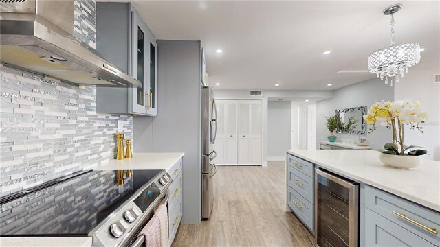 400 Island Way Unit 210, Clearwater Beach, FL 33767 - kitchen with wall chimney exhaust hood, beverage cooler, stainless steel appliances, gray cabinetry, and recessed lighting
