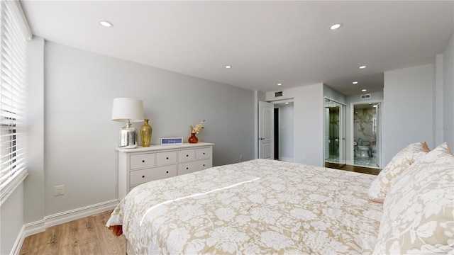 400 Island Way Unit 210, Clearwater Beach, FL 33767 - bedroom with light wood finished floors, recessed lighting, baseboards, and ensuite bathroom