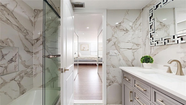 400 Island Way Unit 210, Clearwater Beach, FL 33767 - ensuite bathroom featuring vanity, combined bath / shower with glass door, and tile walls