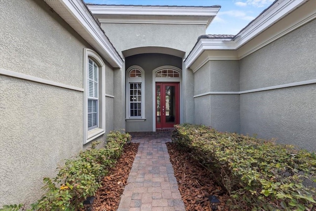 entrance to property featuring stucco siding and french doors