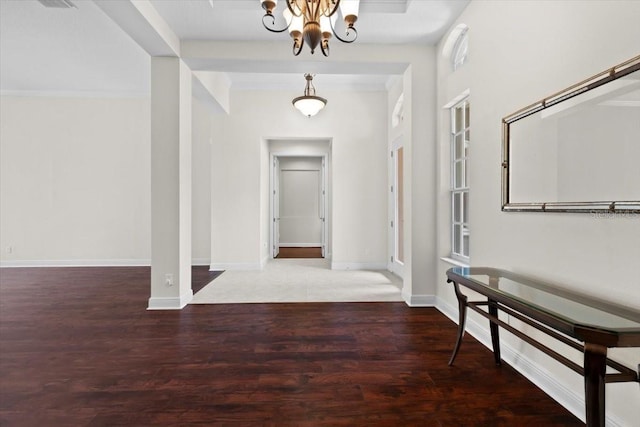 hall featuring an inviting chandelier, baseboards, and wood finished floors