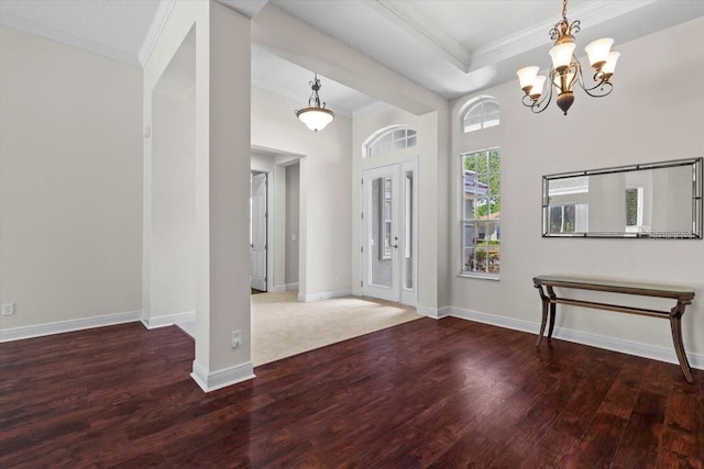 foyer featuring crown molding, wood finished floors, baseboards, and a notable chandelier