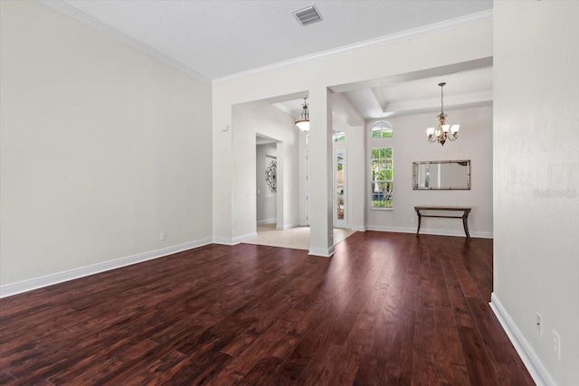 unfurnished living room with wood finished floors, visible vents, baseboards, a chandelier, and ornamental molding