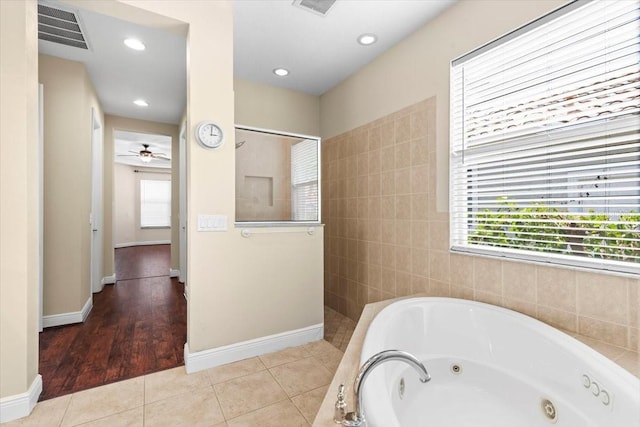 bathroom featuring a tub with jets, walk in shower, a healthy amount of sunlight, and visible vents