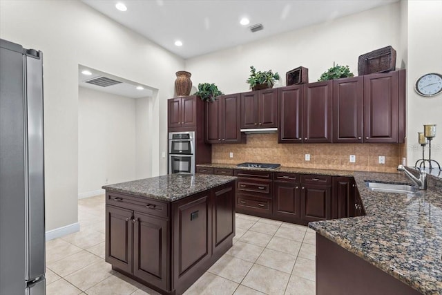 kitchen with a sink, visible vents, decorative backsplash, light tile patterned floors, and appliances with stainless steel finishes