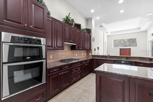 kitchen with a sink, dark stone counters, light tile patterned flooring, backsplash, and appliances with stainless steel finishes