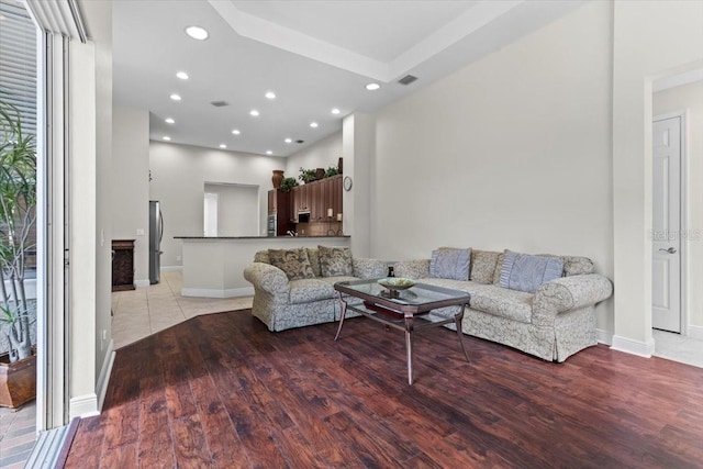 living room with baseboards, light wood finished floors, and recessed lighting