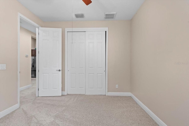 unfurnished bedroom with carpet, a closet, baseboards, and visible vents
