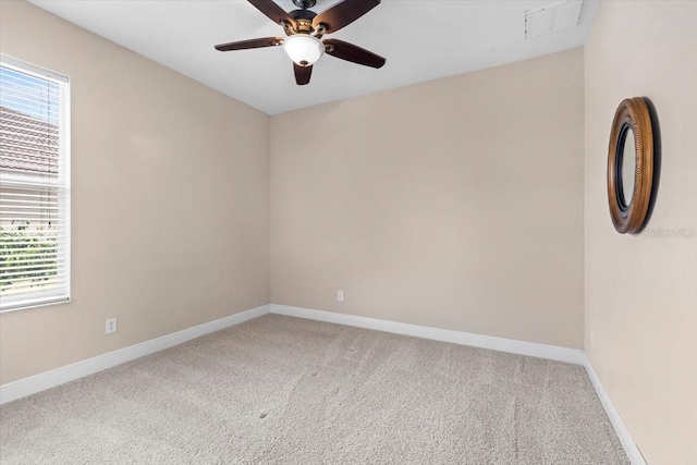 spare room featuring light colored carpet, a wealth of natural light, and baseboards