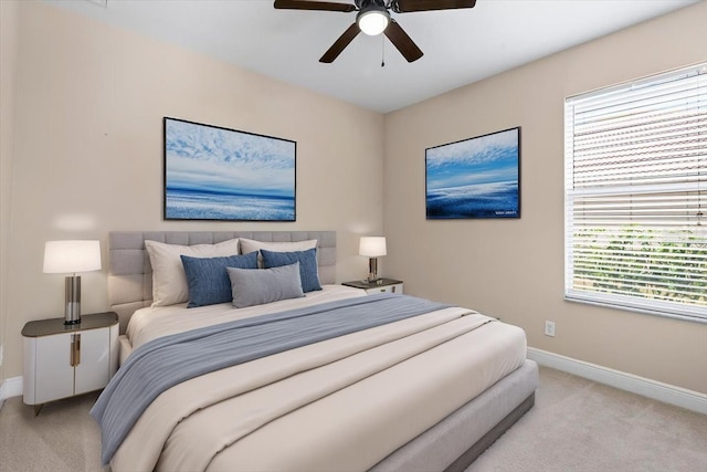 bedroom featuring light colored carpet, baseboards, and ceiling fan