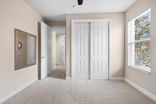 unfurnished bedroom with baseboards, a closet, and carpet floors