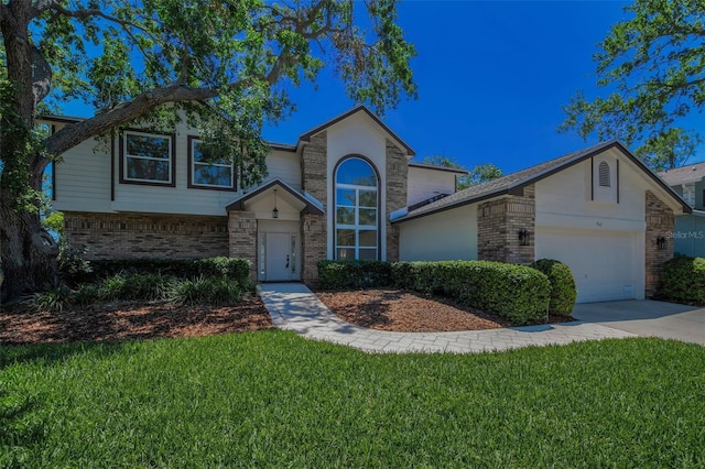 traditional-style home with brick siding, an attached garage, a front lawn, and driveway