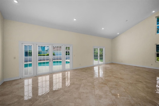 spare room featuring recessed lighting, baseboards, and high vaulted ceiling