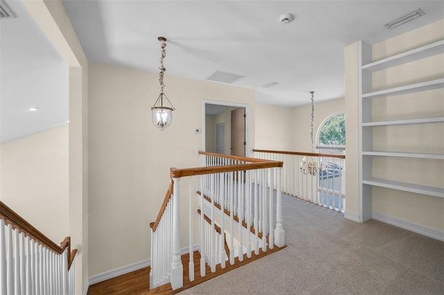 hall featuring an upstairs landing and visible vents