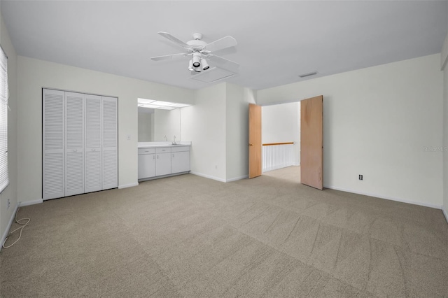 unfurnished bedroom with visible vents, baseboards, light carpet, and a sink