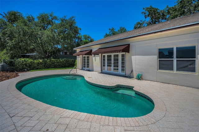 view of pool with a patio, a fenced in pool, and french doors