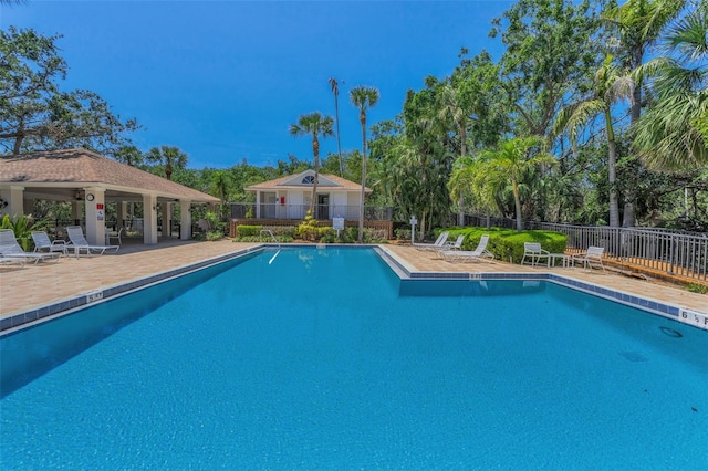 community pool featuring fence and a patio