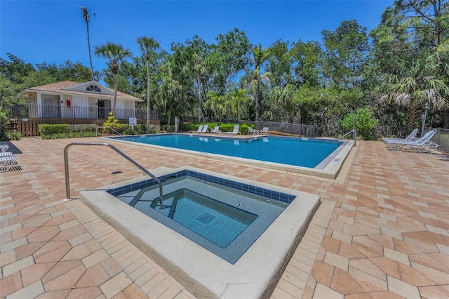 community pool featuring fence, a patio area, and a community hot tub
