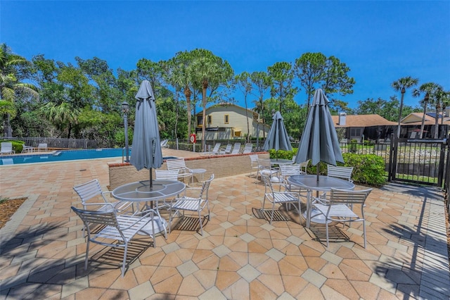 view of patio with fence and a community pool