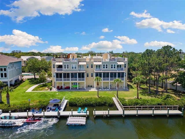 back of house with a lawn and a water view