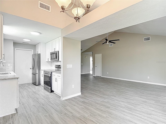 1530 High Knoll Dr, Brandon, FL 33511 - kitchen featuring stainless steel appliances, tasteful backsplash, light wood finished floors, white cabinetry, and lofted ceiling