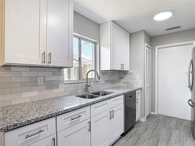 1530 High Knoll Dr, Brandon, FL 33511 - kitchen featuring stainless steel dishwasher, white cabinetry, light stone countertops, tasteful backsplash, and a textured ceiling