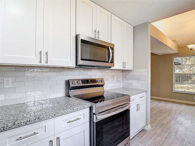 1530 High Knoll Dr, Brandon, FL 33511 - kitchen with stainless steel appliances, light stone counters, and white cabinetry