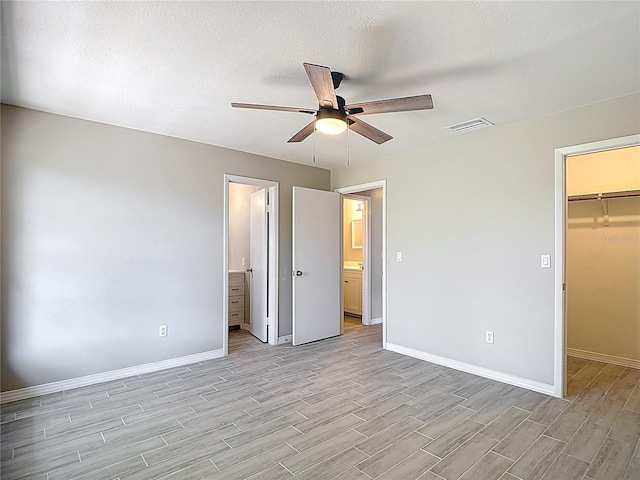 1530 High Knoll Dr, Brandon, FL 33511 - unfurnished bedroom with light wood-style flooring, a spacious closet, a closet, a ceiling fan, and connected bathroom