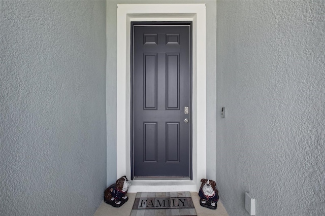 entrance to property featuring stucco siding