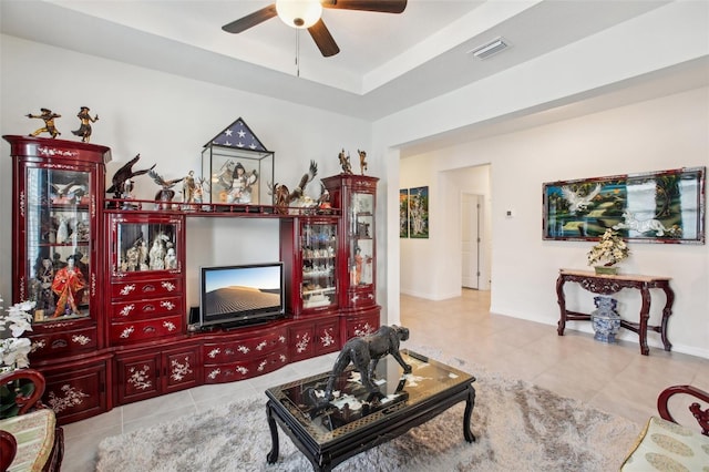 living room featuring visible vents, tile patterned floors, baseboards, and ceiling fan